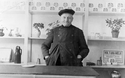 878177 Portret van Aalbert Klein (overleden in 1939), achter de toonbank van zijn melkzaak (Koekoekstraat 28) te Utrecht.